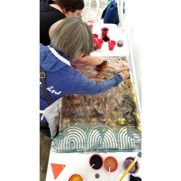 Alunas pintando seu paste paper em conjunto, no workshop que aconteceu no Loucos Por Encadernação 2023.